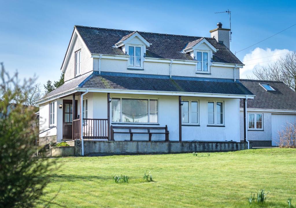 a large white house with a large grass yard at Pelydryn in Abersoch