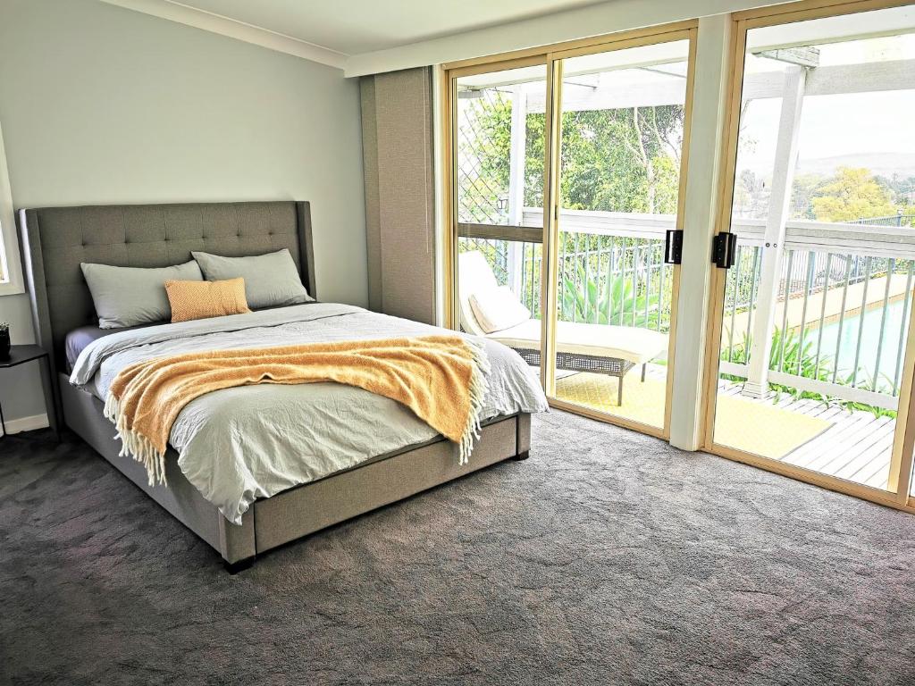 1 dormitorio con 1 cama y balcón en Rare Find! 5-Bedroom Home with Pool and Pool Table en Muswellbrook