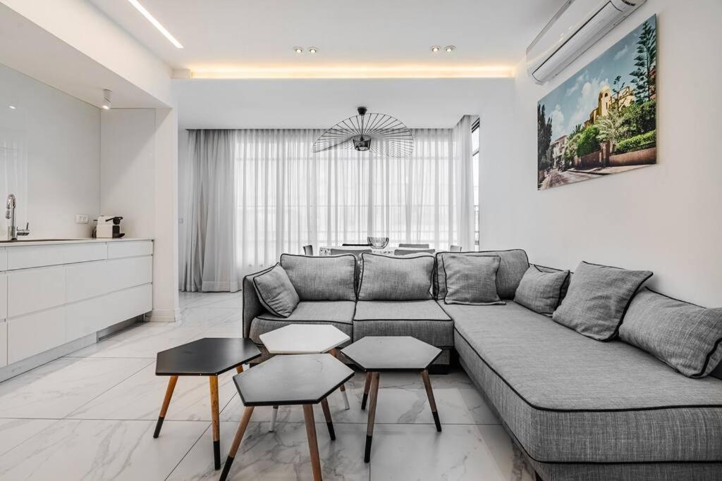 ein Wohnzimmer mit einem Sofa und einem Tisch in der Unterkunft Beautifull 3BR in Masaryk by Holiday-rentals in Tel Aviv