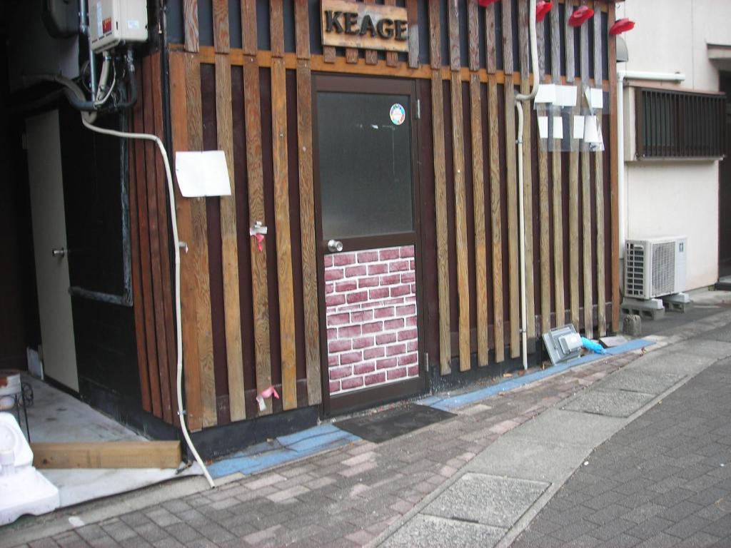 a door of a building with a fence at Guest House Keage in Kyoto