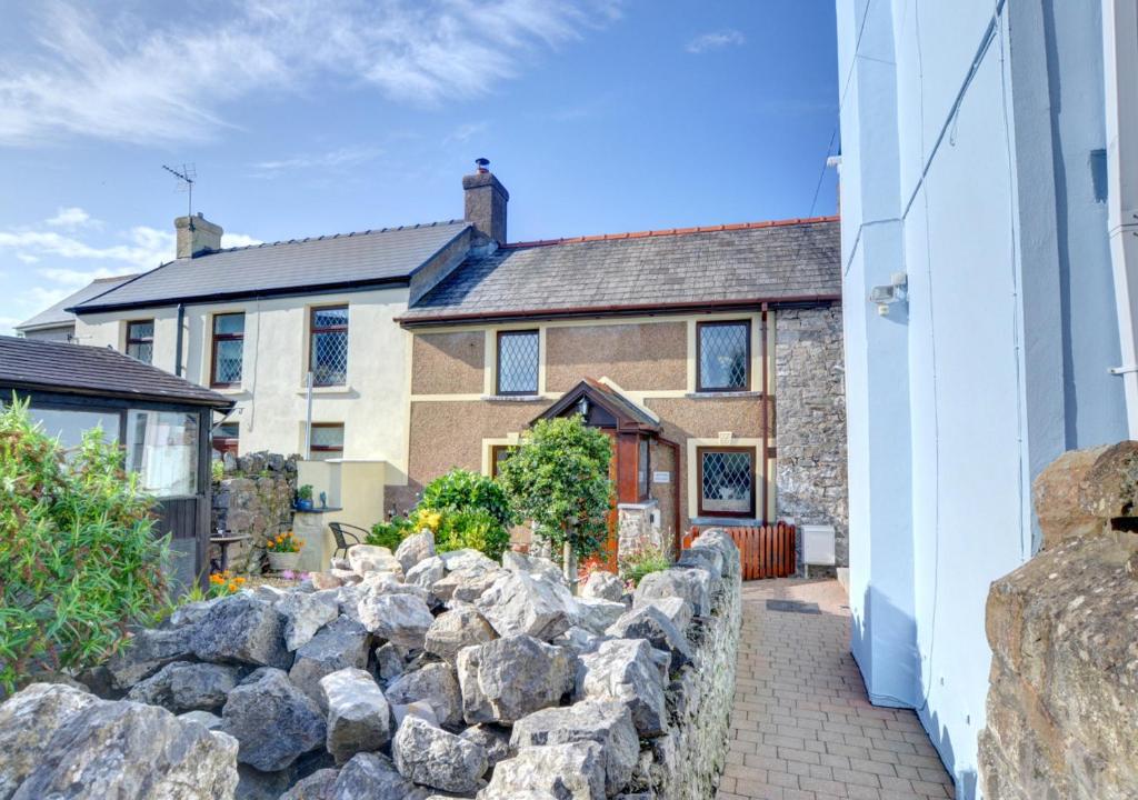 a stone retaining wall in front of a house at Old Newton Cottage in Porthcawl