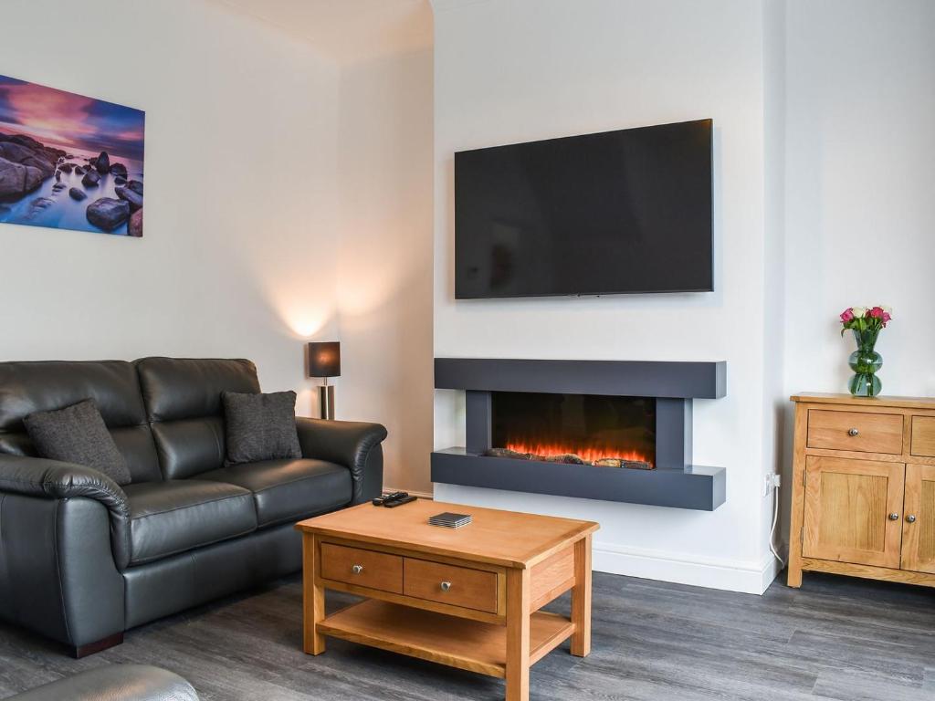 a living room with a couch and a fireplace at Excalibur Cottage in Saint Annes on the Sea