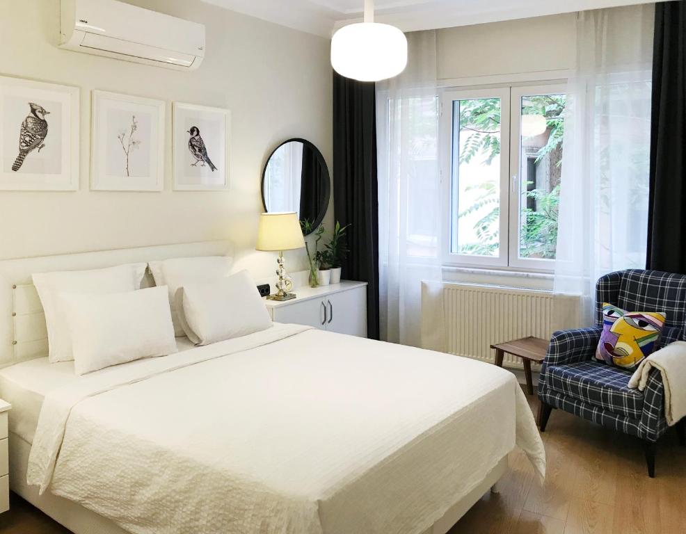 - une chambre avec un lit blanc et une chaise dans l'établissement MY FABULOUS HOME in TAKSIM BEYOGLU, à Istanbul