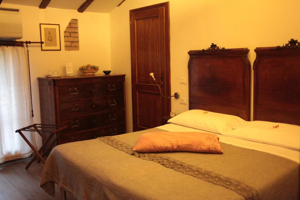 - une chambre avec un lit doté d'une tête de lit en bois et d'une commode dans l'établissement Agriturismo Il Cucco, à Altedo