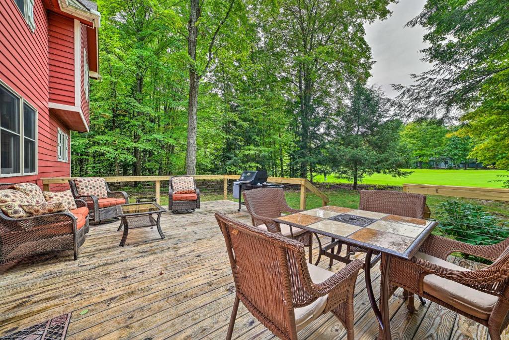 a deck with a table and chairs and a grill at Bellaire Home with Golf Course View and Pool Access! in Bellaire