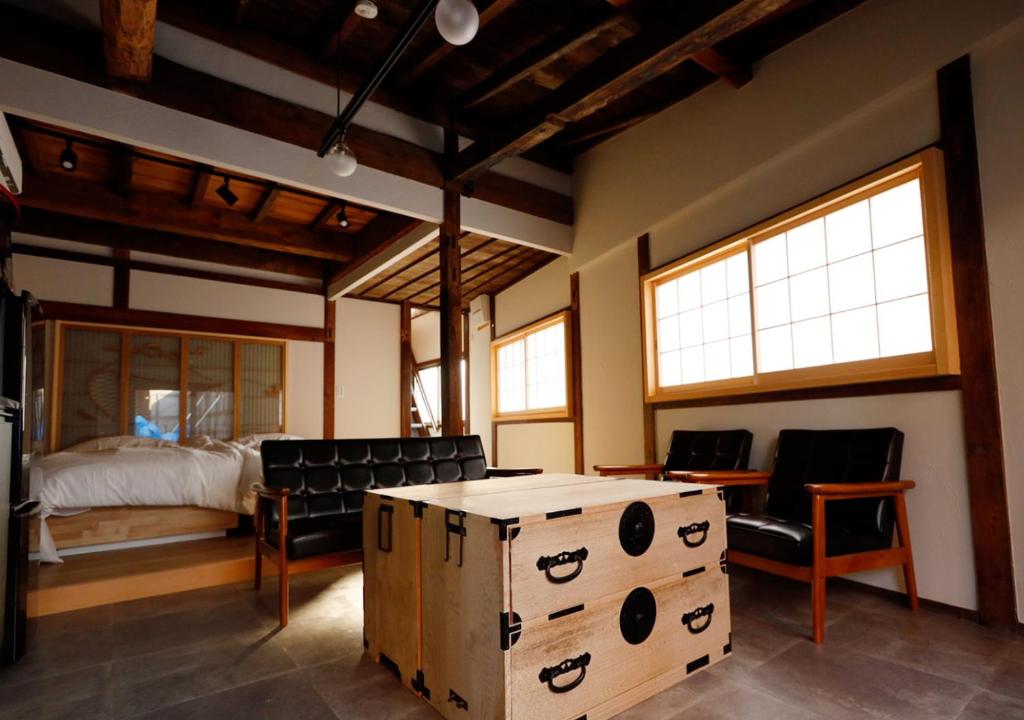 1 dormitorio con 1 cama, mesa y sillas en 星のワルツ　御家堂(Oiedo) en Komoro