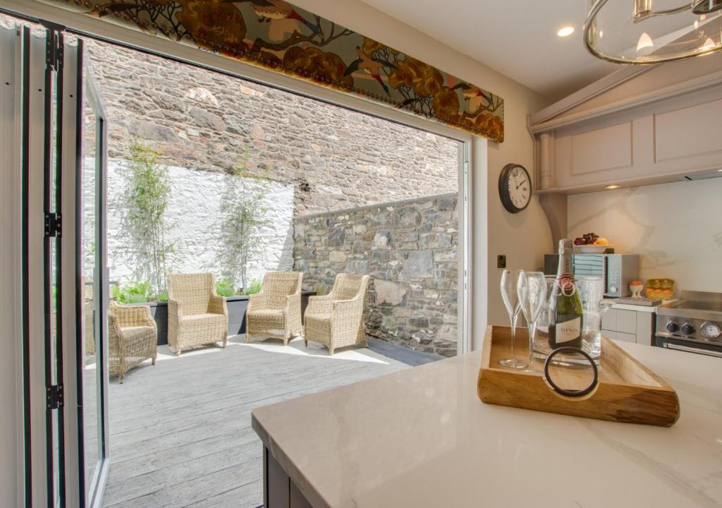 een keuken met een glazen schuifdeur naar een patio bij Mulberry Cottage in Conwy