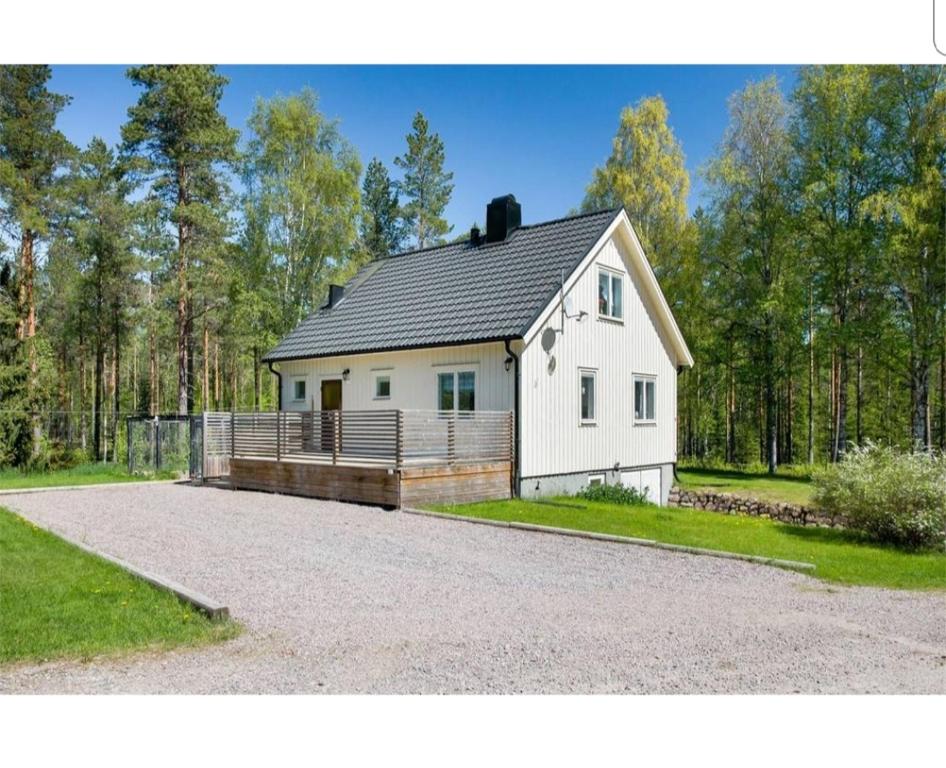 una casa blanca con techo de gambrel en una entrada en Dream of Dalarna by Tanja, en Vansbro
