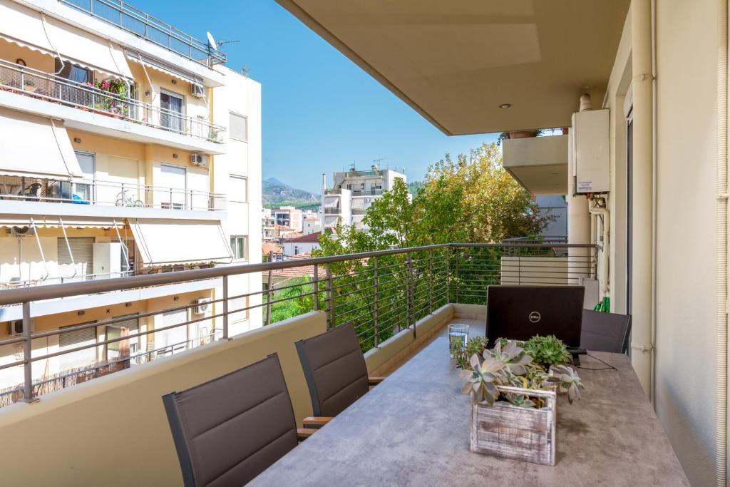 balkon ze stołem i laptopem w obiekcie Eleni's modern apartment w mieście Wolos