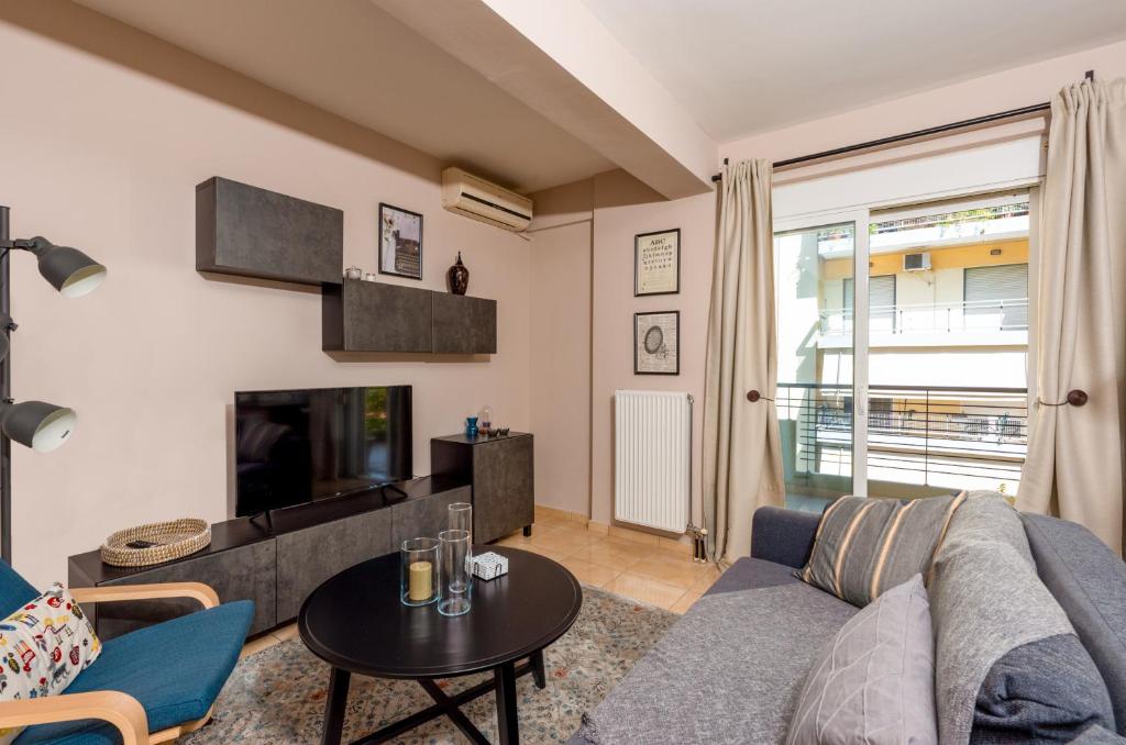 salon z kanapą i telewizorem w obiekcie Eleni's modern apartment w mieście Wolos
