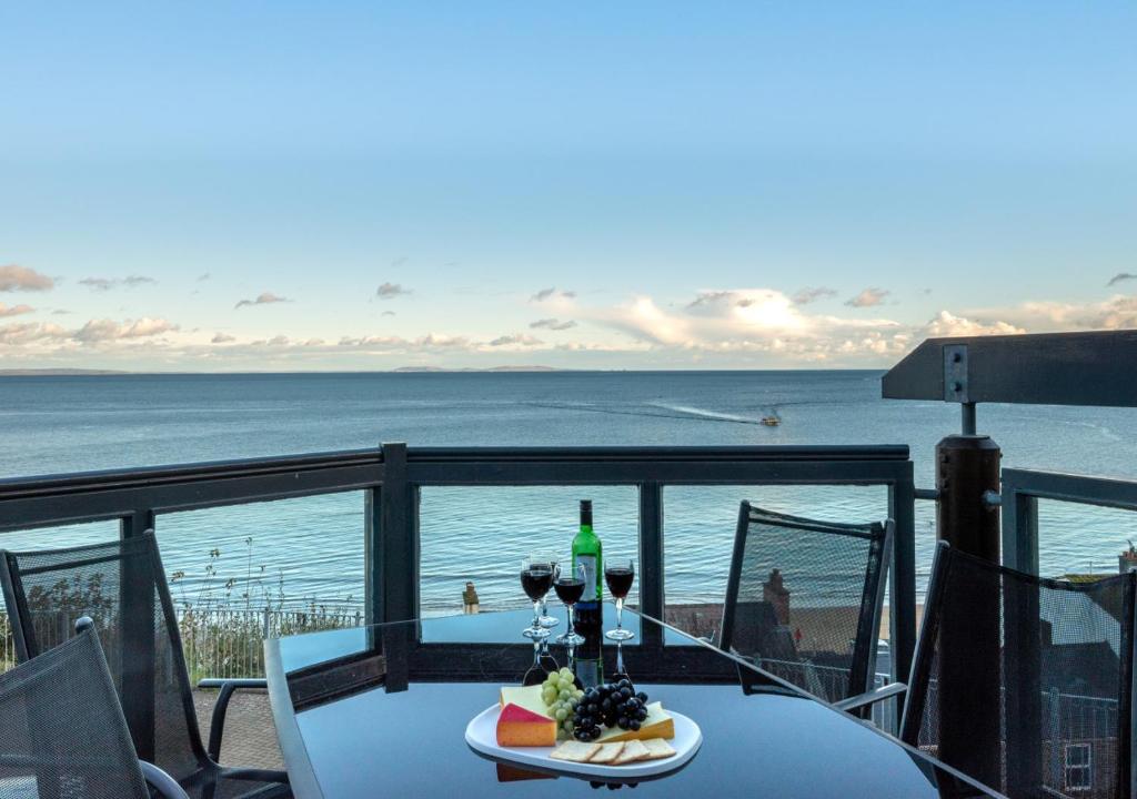 サンダースフットにあるThe Chandleryの海を望むバルコニーにテーブル(ワイングラス付)と食事