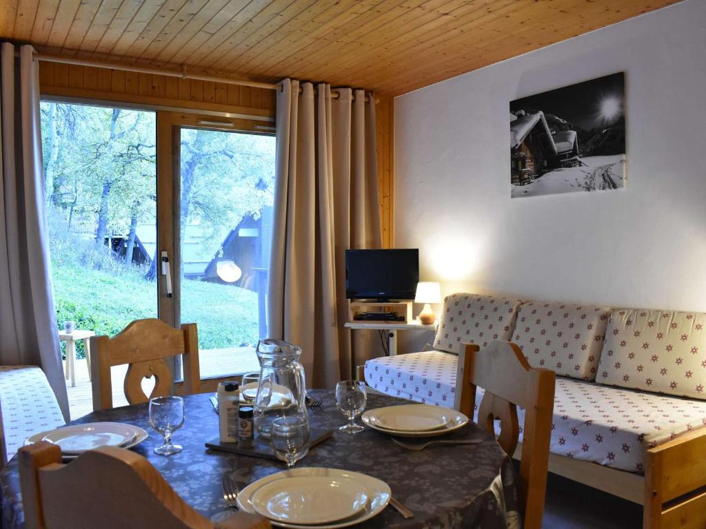 une salle à manger avec une table, des chaises et une télévision dans l'établissement Studio confortable pour 4 pers, balcon sud, proche pistes et commerces - Méribel - FR-1-180-26, à Méribel