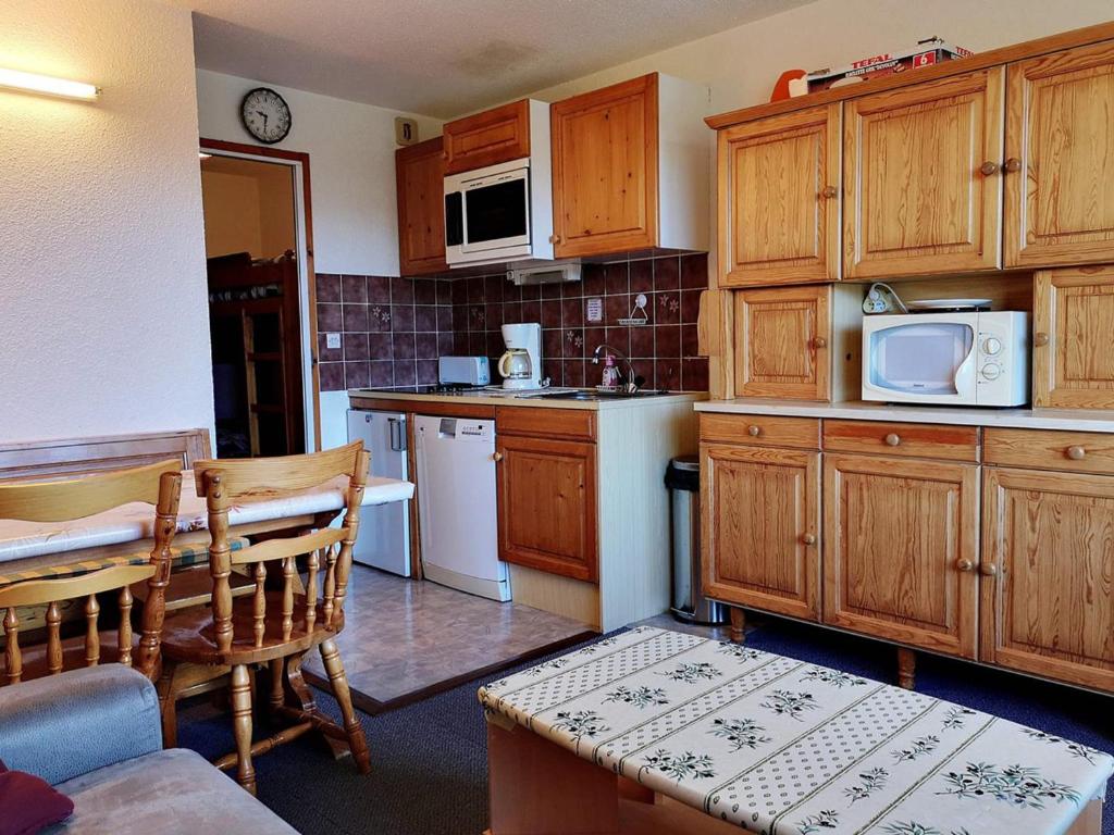 eine Küche mit Holzschränken und einem Tisch mit Mikrowelle in der Unterkunft Appartement Notre-Dame-de-Bellecombe, 1 pièce, 6 personnes - FR-1-595-5 in Notre-Dame-de-Bellecombe