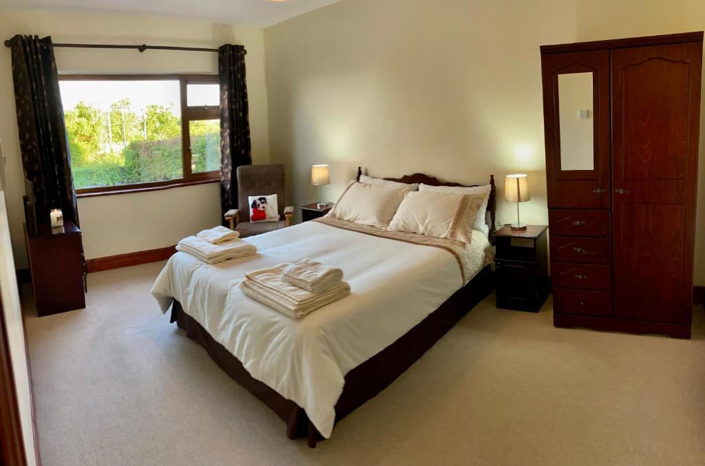 a bedroom with a large bed with towels on it at Lily's - 3 Bedroom Country Cottage with Large Garden in Sligo