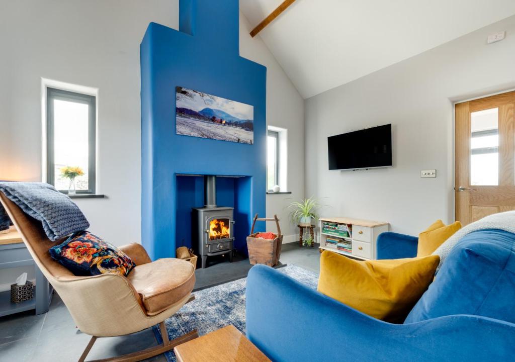 a living room with a blue accent wall at Gwêl y Grib in Pen-y-groes