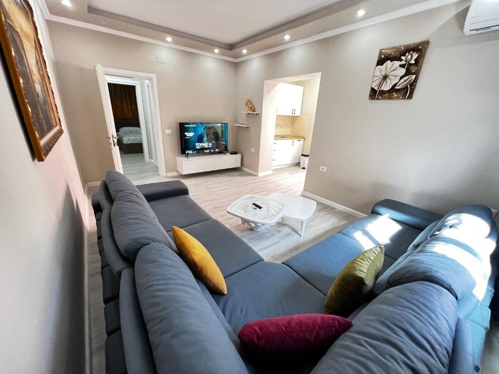 Golden Cherry في تيرانا: غرفة معيشة بها أريكة زرقاء وتلفزيون