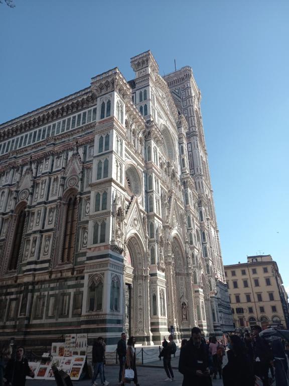 ein großes Gebäude mit Leuten, die davor laufen in der Unterkunft Dependace il David di Michelangelo in Florenz