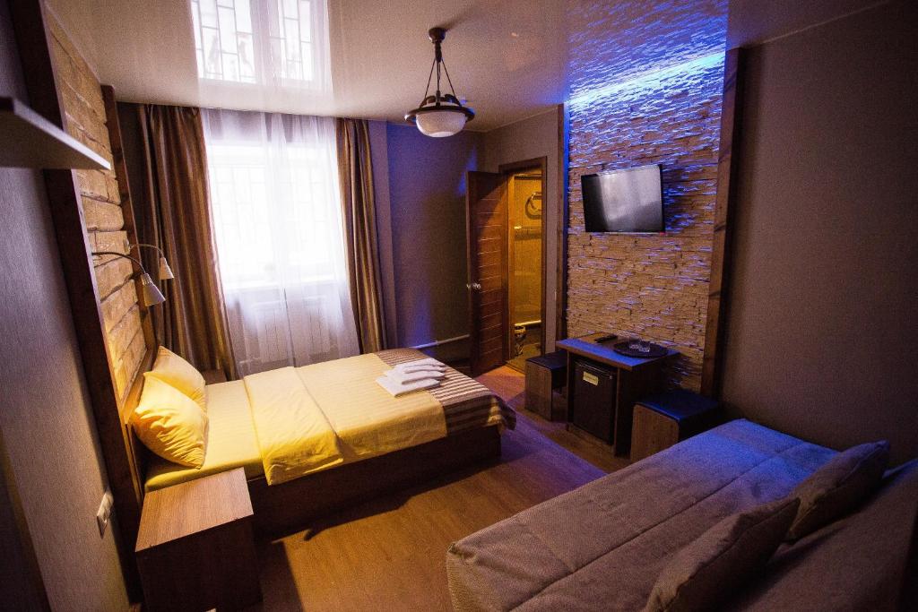 ウラン・ウデにあるHotel Kochevnik na Limonovaのベッド1台とテレビが備わる小さな客室です。
