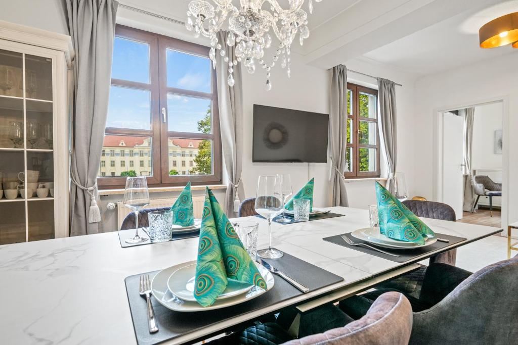 una sala da pranzo con tavolo, sedie e lampadario pendente di Schlossblick Tettnang a Tettnang
