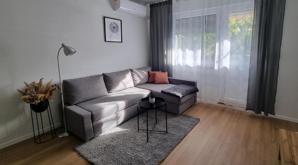 a living room with a couch and a window at RetFala Inn in Osijek