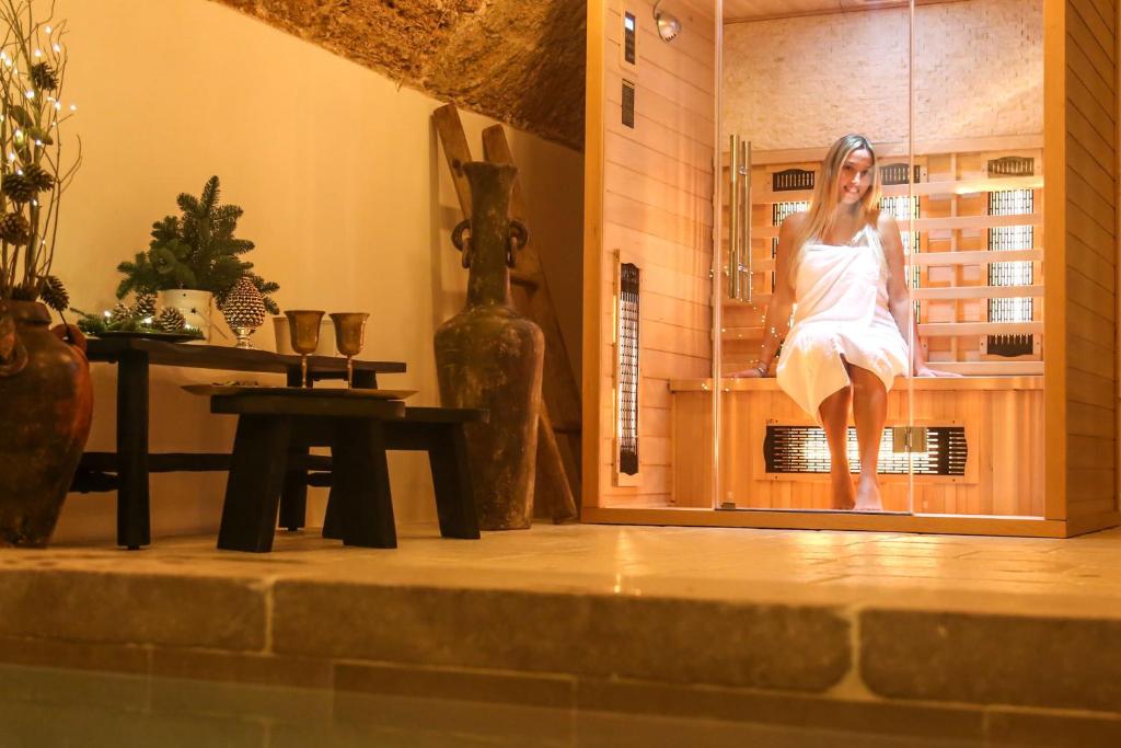 a woman sitting in a chair in a room at CORTE LARGO LAURO DIMORE & SPA in Gemini