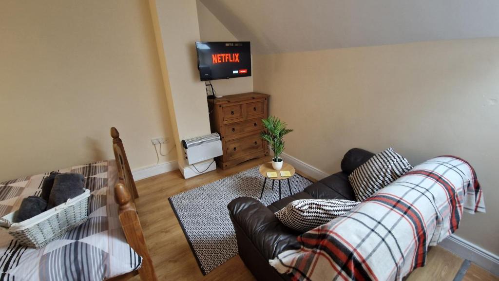 a living room with a couch and a tv at Apple Lodge Apartment in Forkill