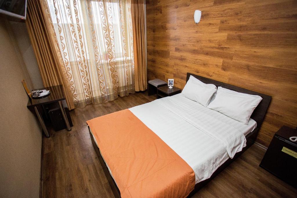 ウラン・ウデにあるHotel Kochevnik na Zherdevaの大きなベッドと木製の壁が備わるベッドルーム1室が備わります。