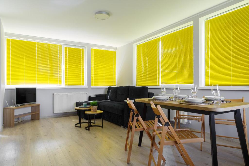 una sala de estar con persianas amarillas en las ventanas en Camping Oaza Błonie Kórnik Domki Standard Plus - 3 pokoje en Kórnik