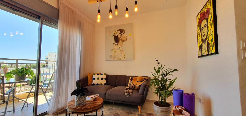 a living room with a couch and a balcony at מלוני דירות נופש אילת - Melony Apartments Eilat in Eilat