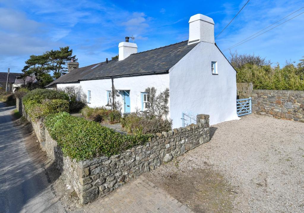 Casa blanca con pared de piedra en Pengarth Cottage, en Abersoch