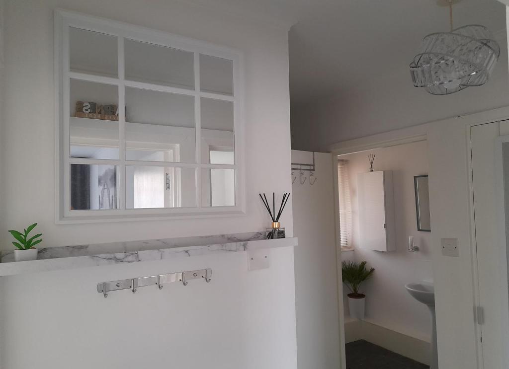 uma cozinha branca com uma janela e um lavatório em Whole Apartment with Balcony Breakfast & Parking em Bishop Auckland