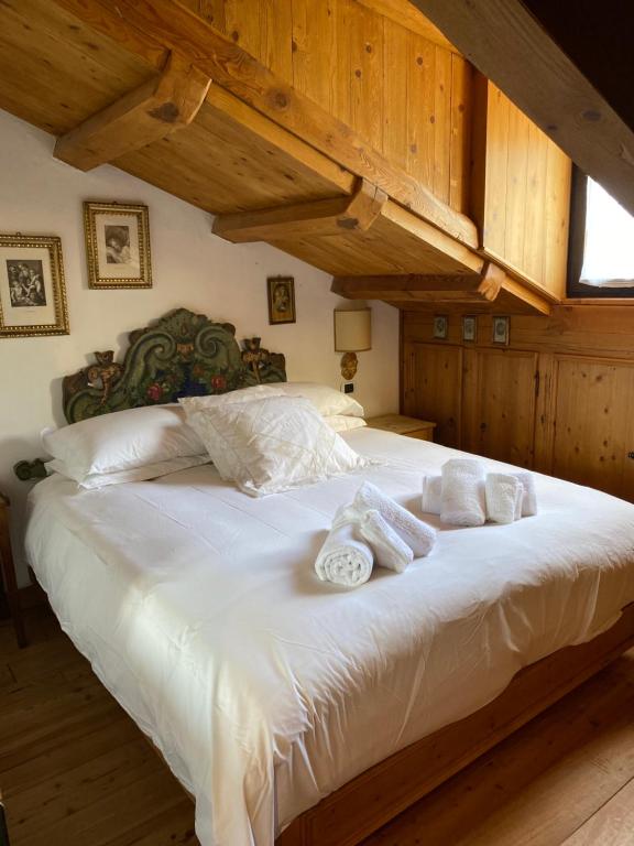 a bedroom with a large white bed with towels on it at Appartamento Laura in Madonna di Campiglio