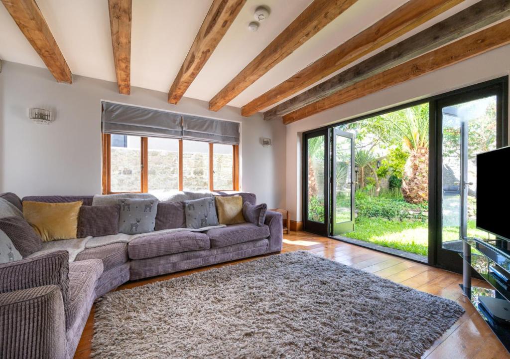 uma sala de estar com um sofá e uma grande janela em Wall Cottage Group em Tenby