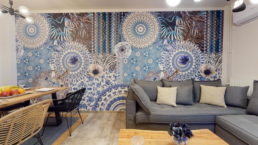 a living room with a couch and a wall mural at Motley Luxury Apartment by Estia in Heraklio Town