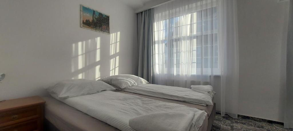 um quarto com uma cama e uma janela em Hostel Centrum-Kamienica 1924 em Szczecinek