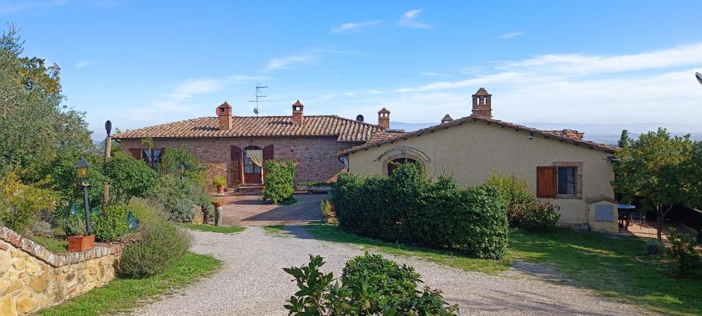 una casa grande con una entrada delante de ella en Le Corolle en Montepulciano