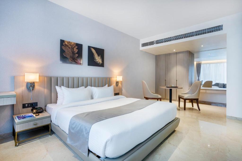 um quarto de hotel com uma cama, uma mesa e cadeiras em Hotel Luxy em Dahej