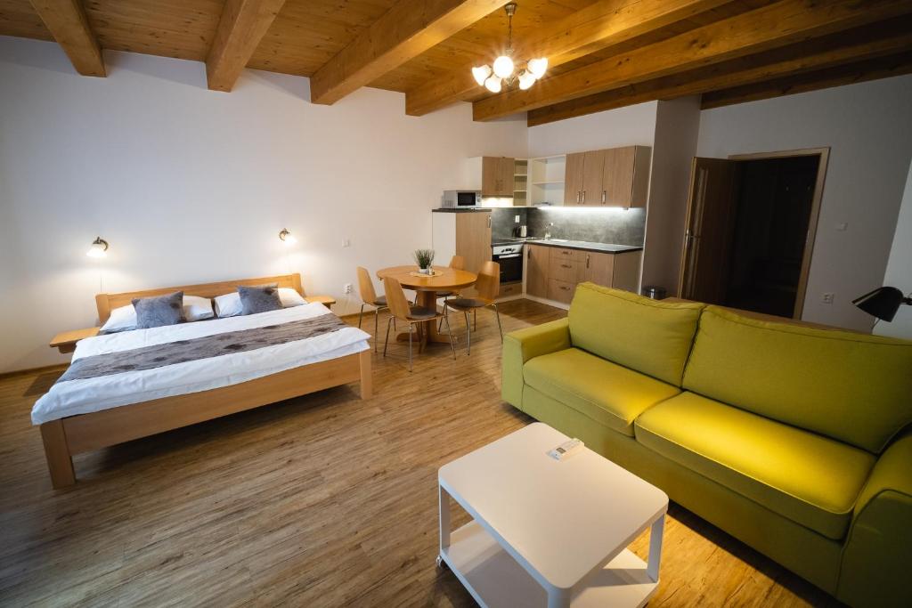 1 dormitorio con cama, sofá y mesa en Apartmany 21 Třeboň, en Třeboň