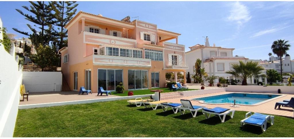 une grande maison avec une piscine dans la cour dans l'établissement Villa Ramos, à Albufeira