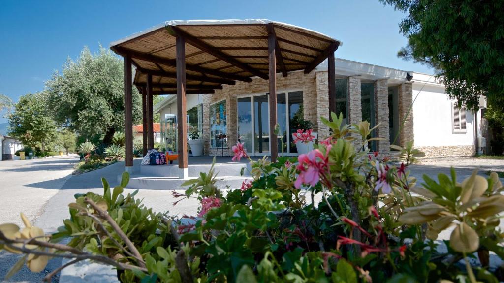 a garden area with a patio with flowers in it at Villaggio Le Palme in Ascea