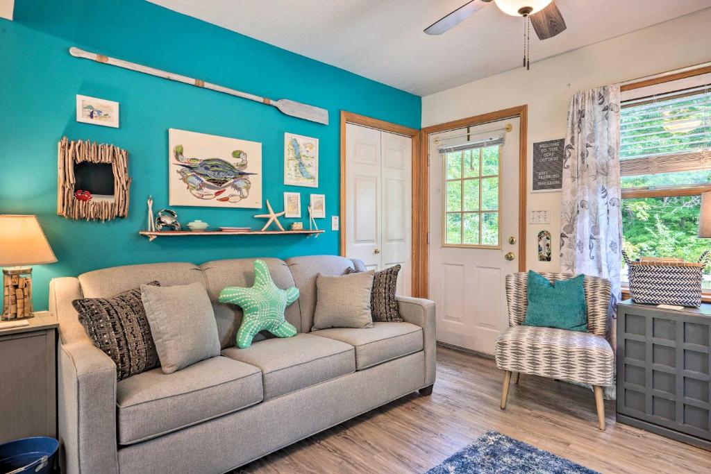 salon z kanapą i niebieską ścianą w obiekcie Darling Cottage about 1 Mi to Lake Erie Beach! w mieście North East