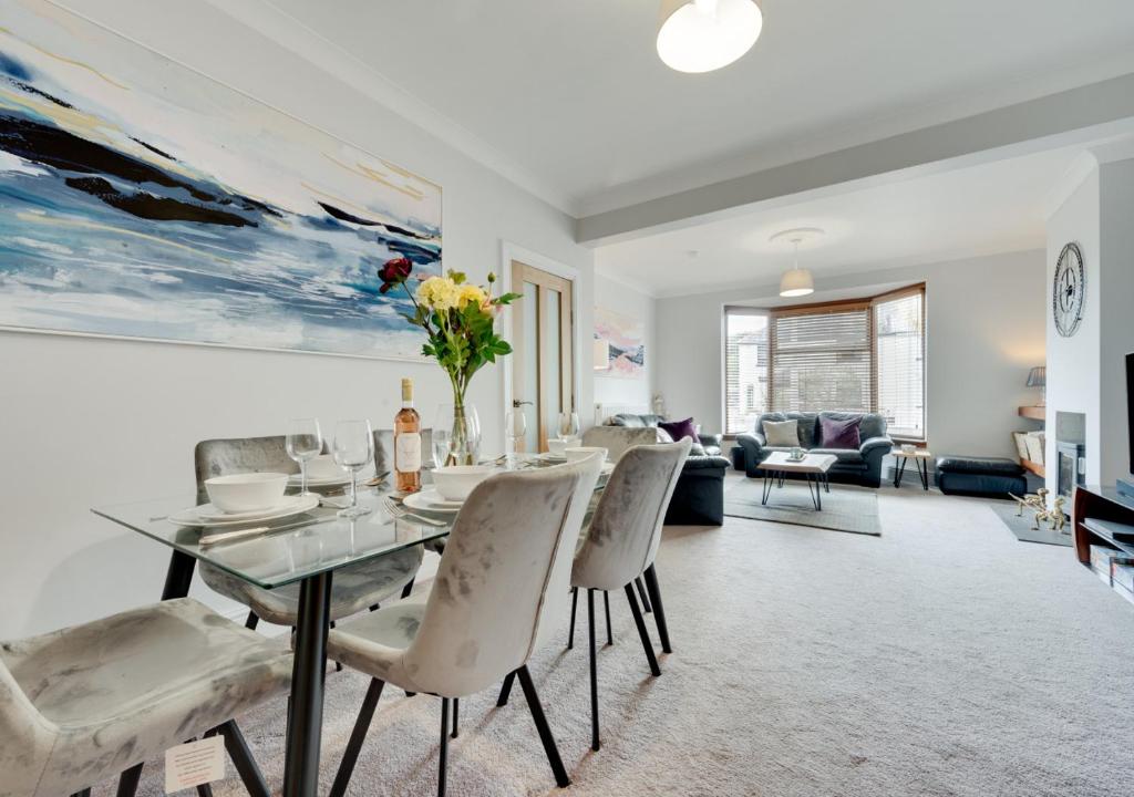 a dining room and living room with a table and chairs at Home Croft in Tenby