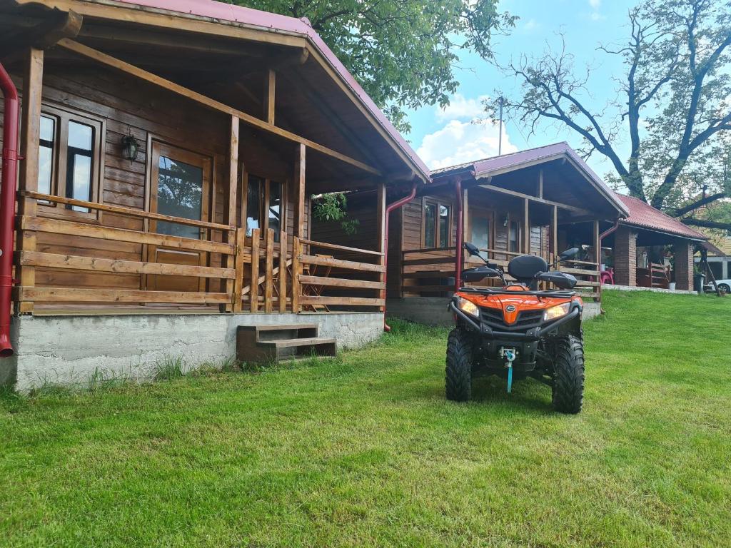 una moto de tierra estacionada frente a una cabaña de madera en Cabanuțele din Lemn en Chişcău