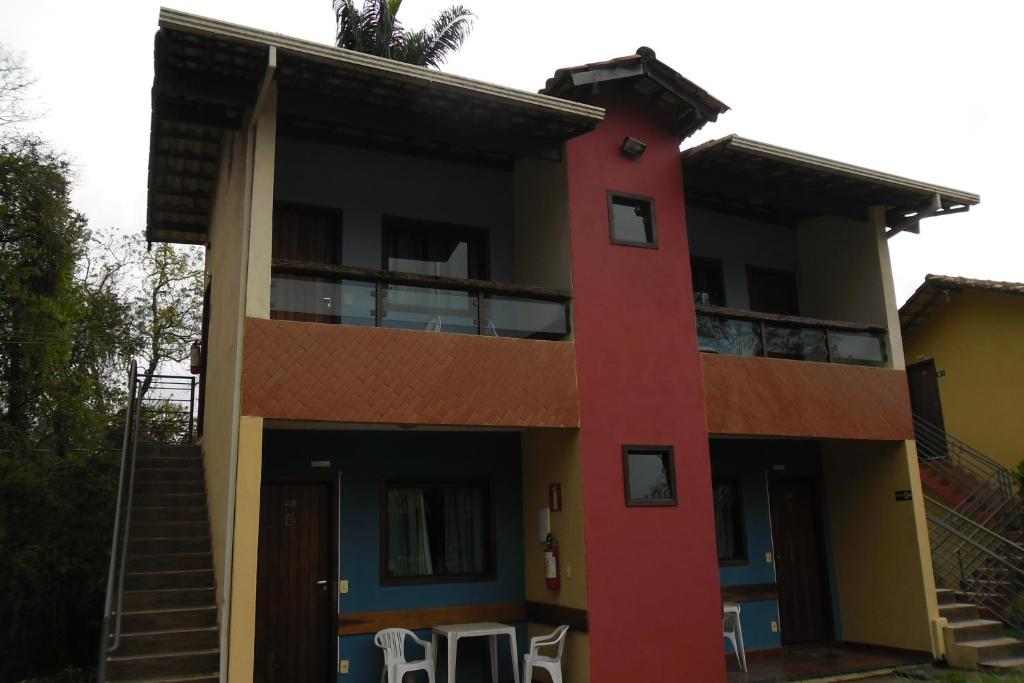 猴市的住宿－Pousada Marumbe，前面有椅子的红色建筑