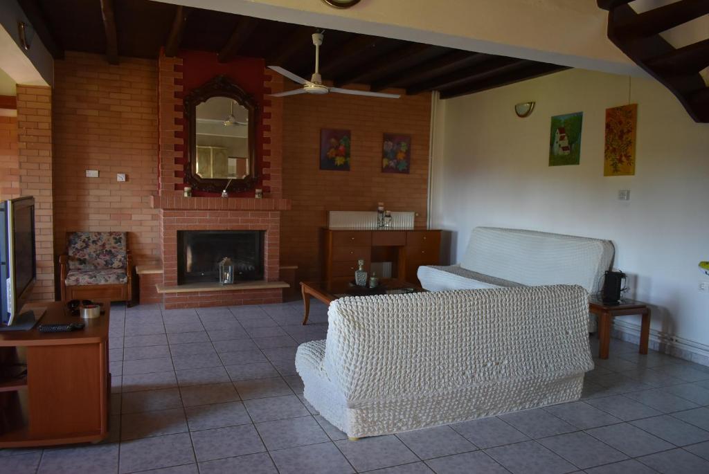 a living room with a couch and a fireplace at Kerasia's and Dora's garden in Punta