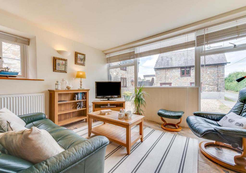 a living room with a couch and a tv at Pigsty Cottage in Knelston