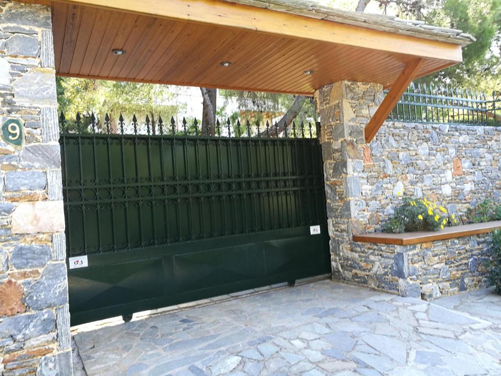 une porte noire avec un toit en bois sur un mur en pierre dans l'établissement A cosy 60 Sq. m. entire villa, à Pendéli