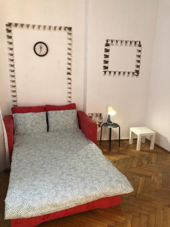 - une chambre avec un lit et une horloge murale dans l'établissement Pokój 11C, à Cracovie