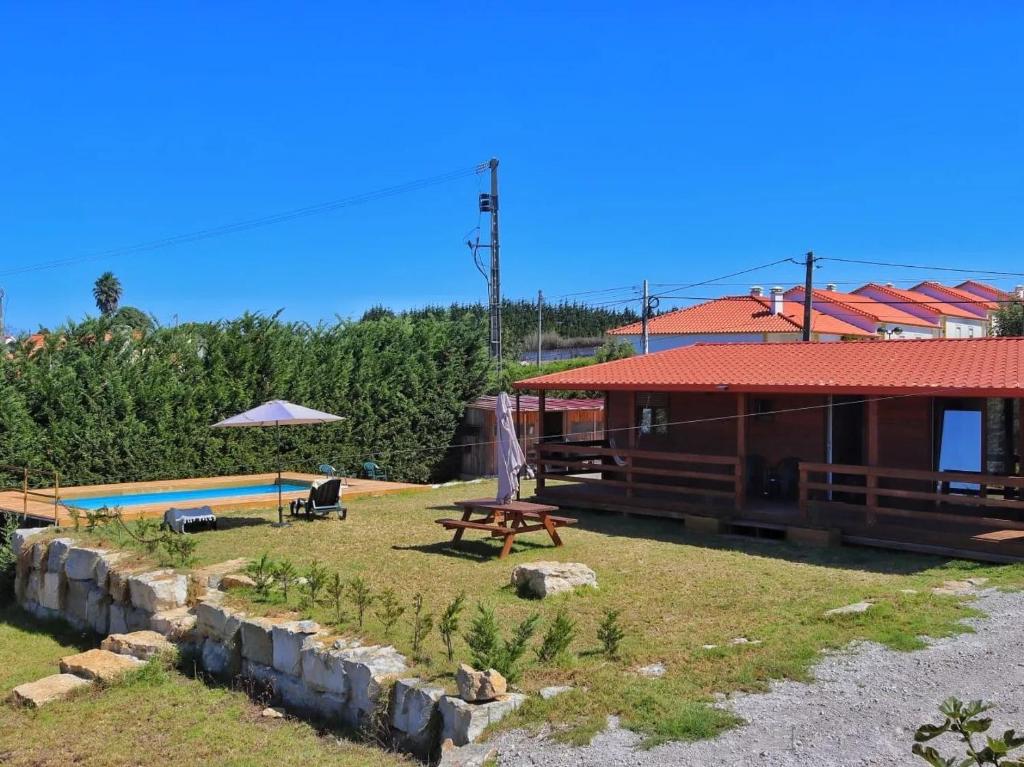 a house with a picnic table and a pool at Quinta do Sol in Lourinhã