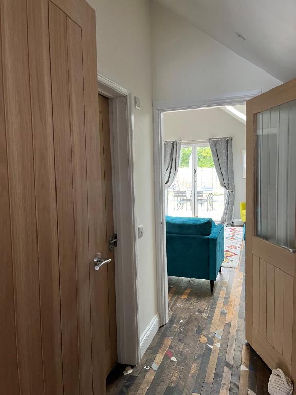 a living room with a blue couch and a door at Lime Tree Cottage in Tillingham